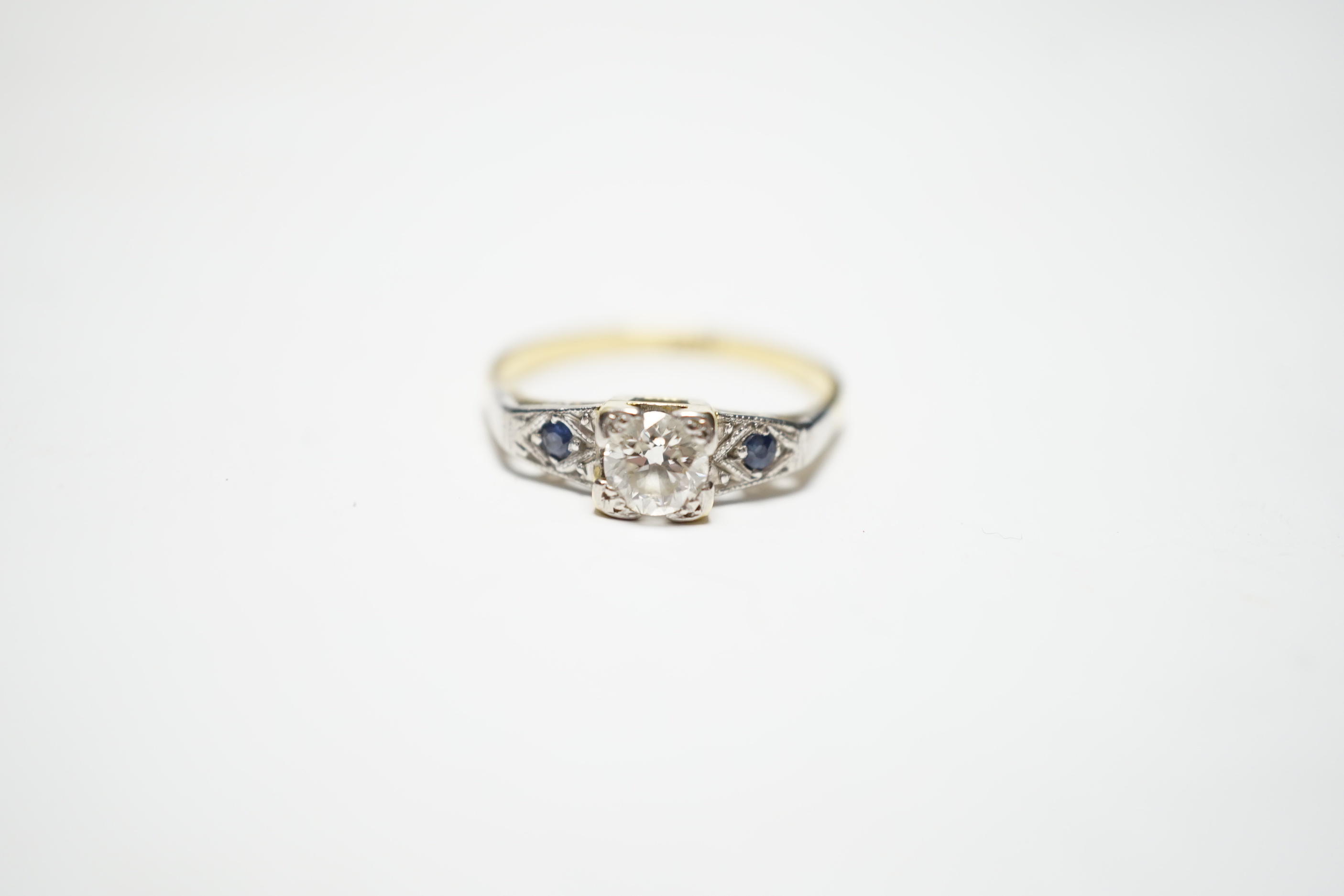 An 18ct and single stone diamond ring, with sapphire set shoulders, size N, gross weight 3.6 grams.